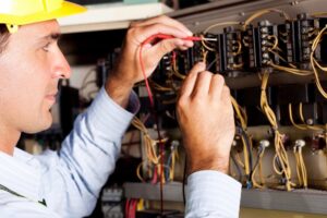 Electrician using a multimeter to test an electrical panel